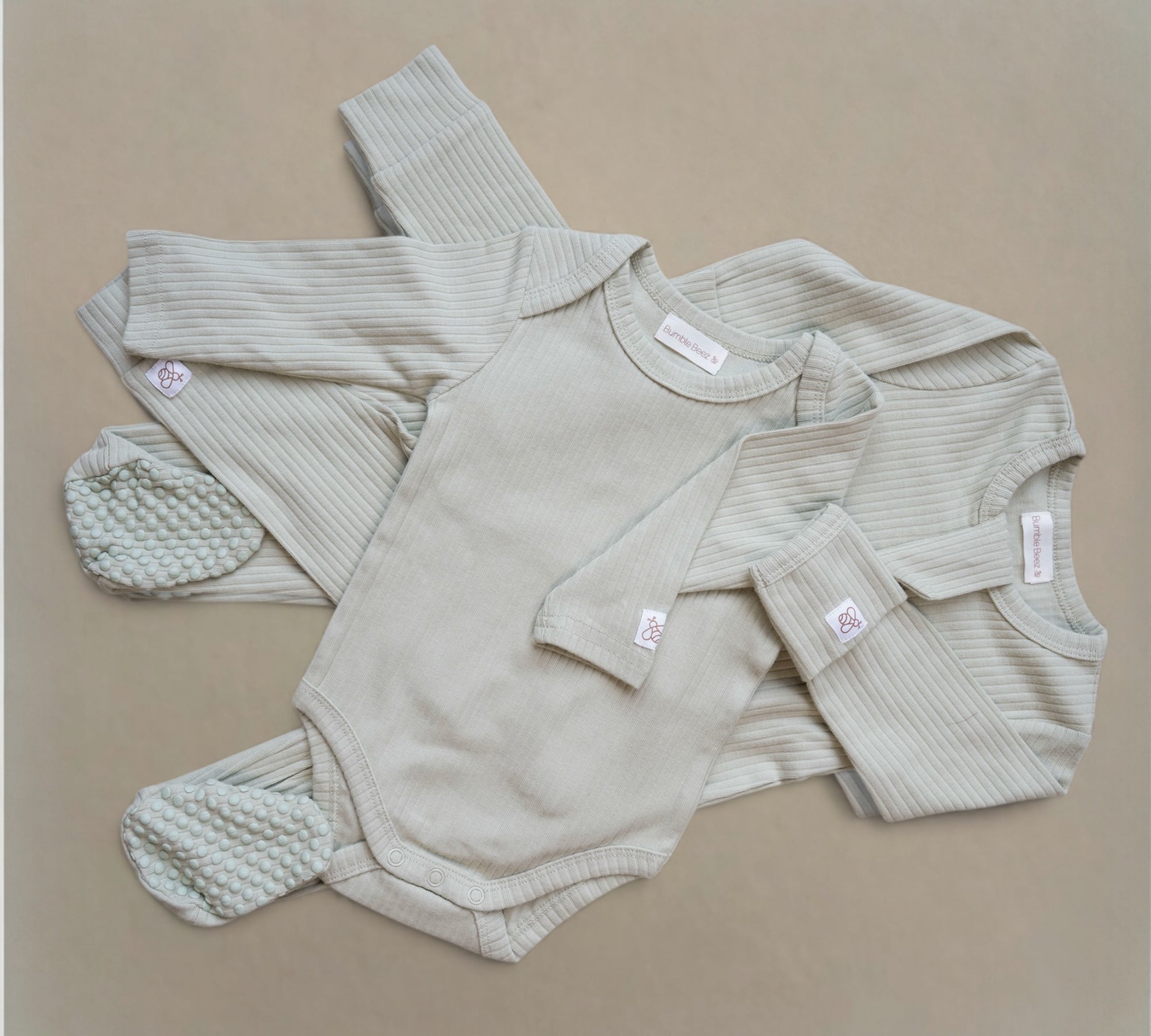 Organic ribbed cotton three-piece toddler Ribbed Set in neutral mushroom color with long sleeve vest, leggings, and zip-through grow for comfort and easy wear