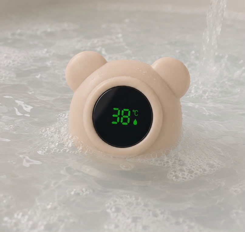 Floating baby bath thermometer with digital LED display and cute bear design in soft beige color