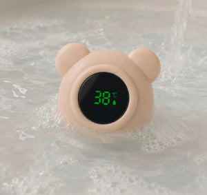 Floating baby bath thermometer with digital LED display and cute bear design in soft beige color