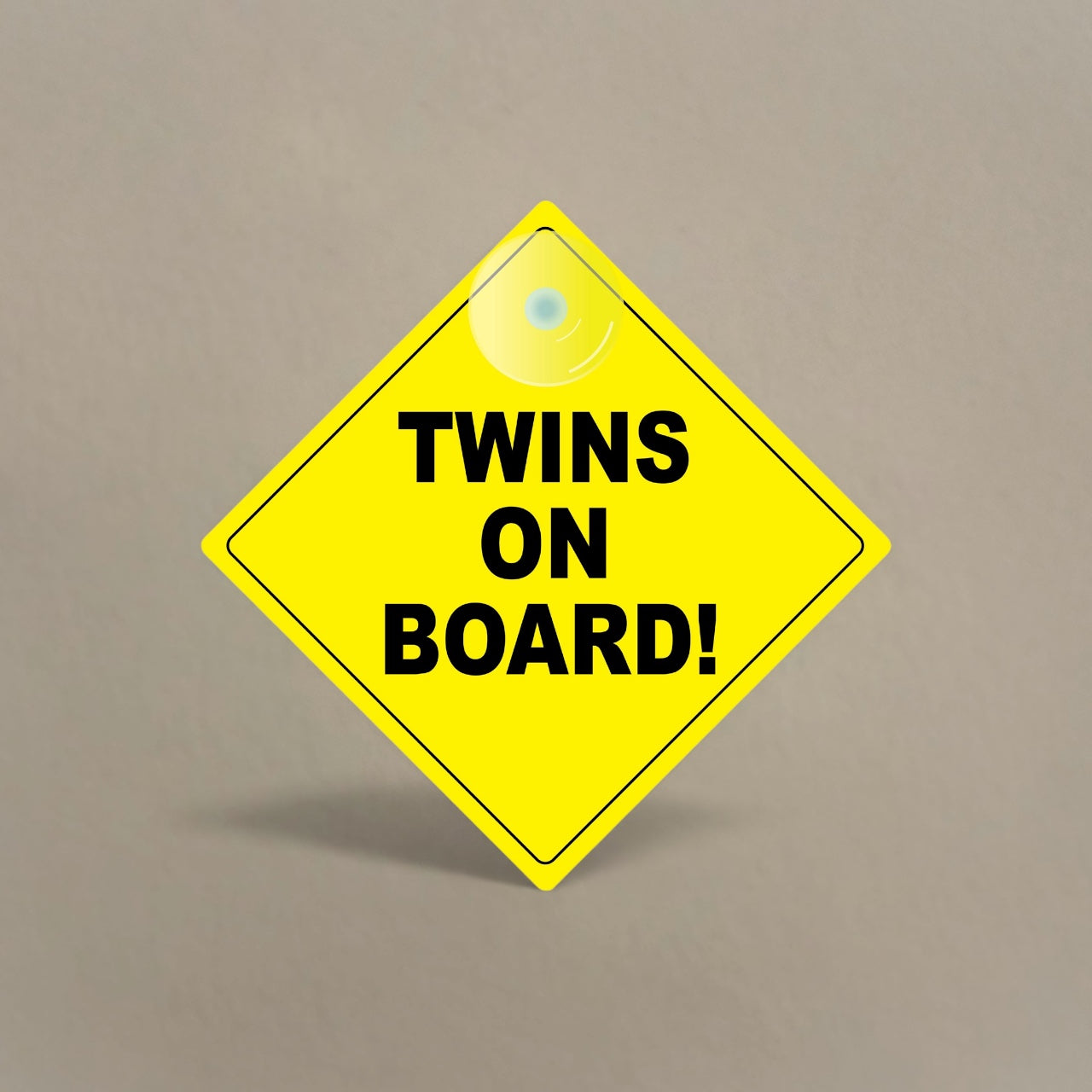 Bright yellow Twins On Board car sign with suction cup for window attachment and black lettering for visibility