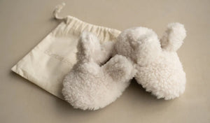 Soft oat-colored Bouclé Bunny Booties for newborns with cotton ties and soft soles, displayed with a cotton drawstring bag.