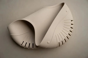 The Drift Bath Organiser in soft beige silicone with perforated drainage and dual compartments for baby bath essentials