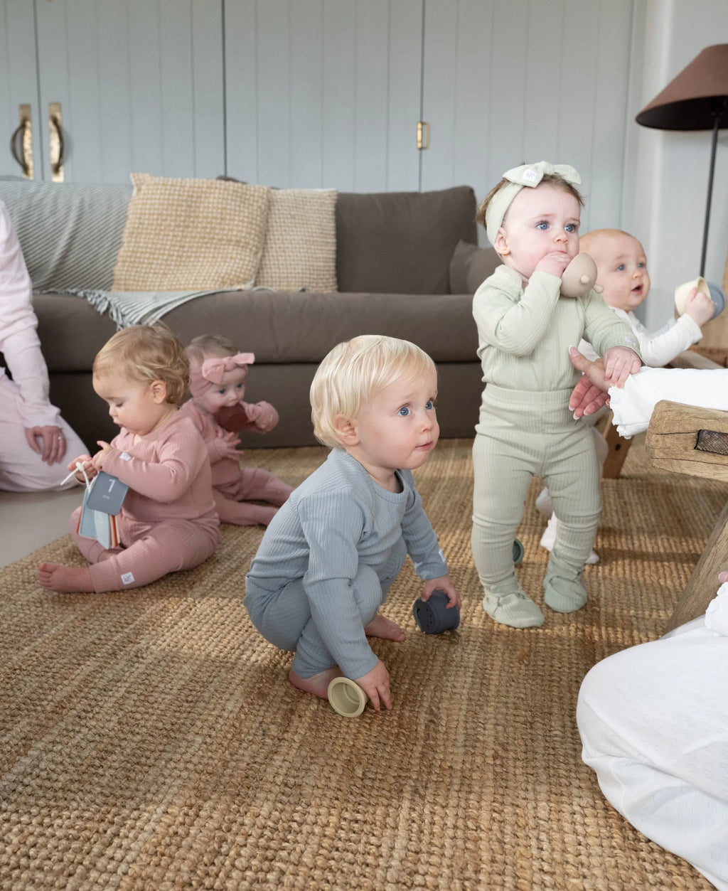 Toddlers wearing soft organic cotton ribbed set in pastel shades playing indoors on woven rug